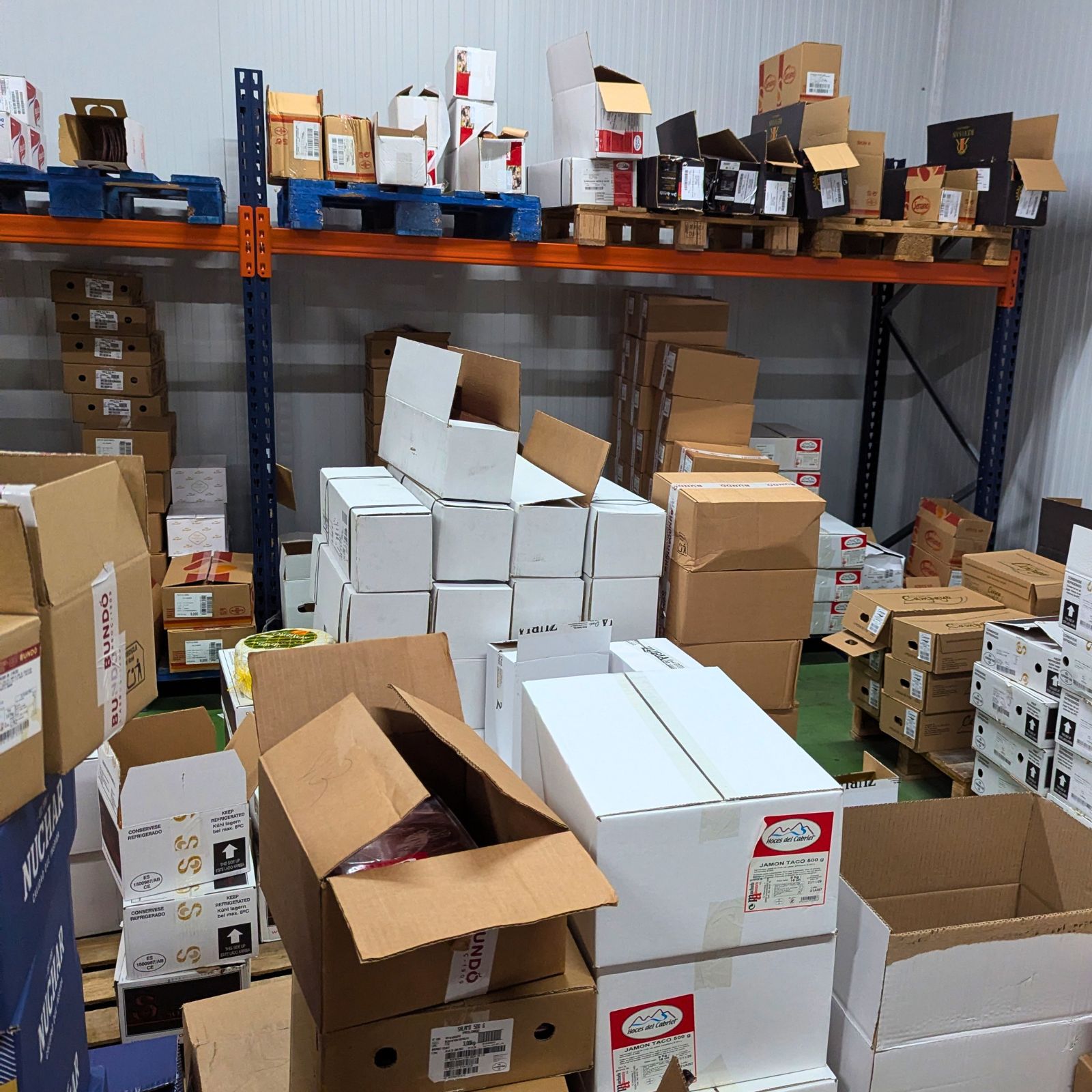 Cajas apiladas en almacén industrial con estanterías