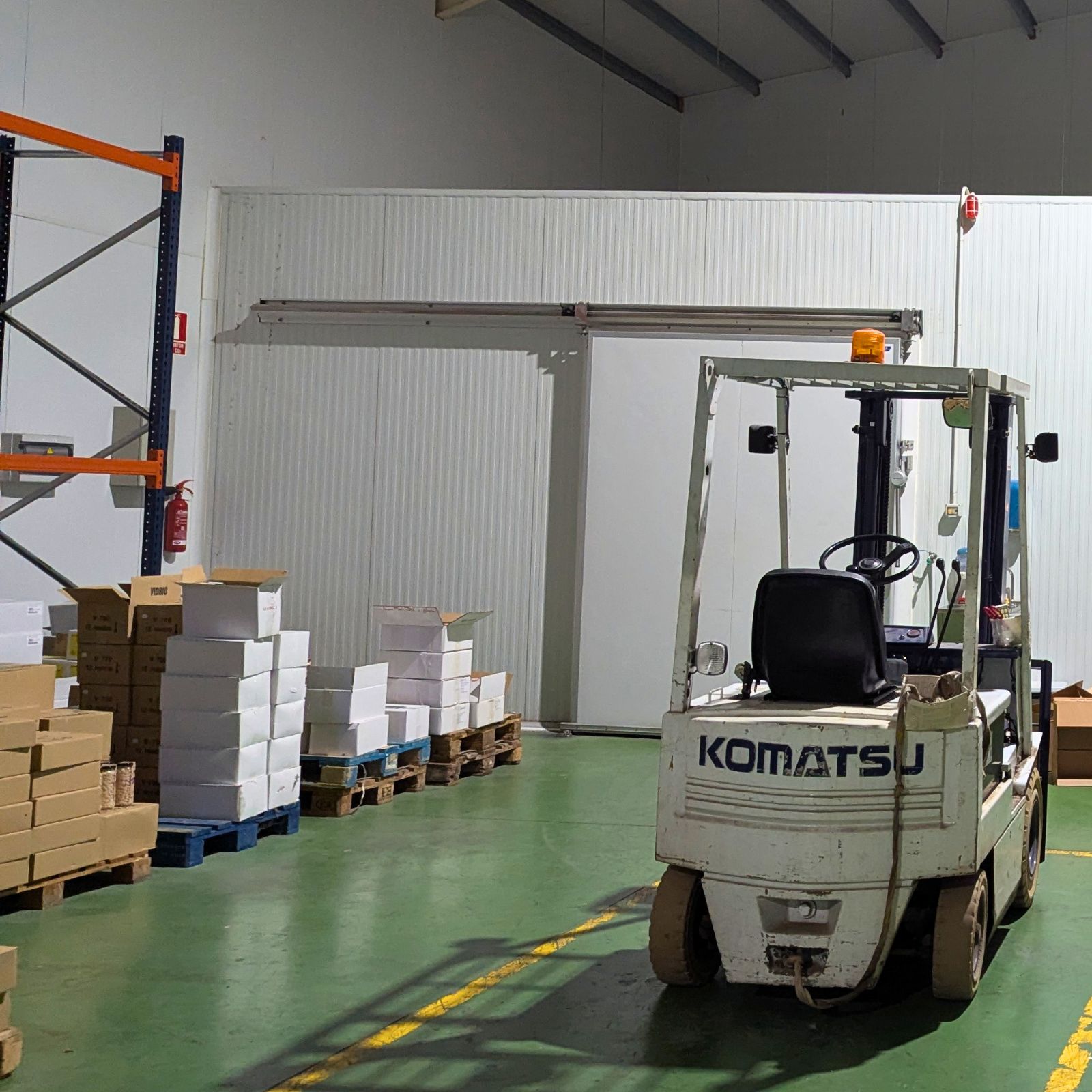 Carretilla elevadora en almacén con palets y cajas